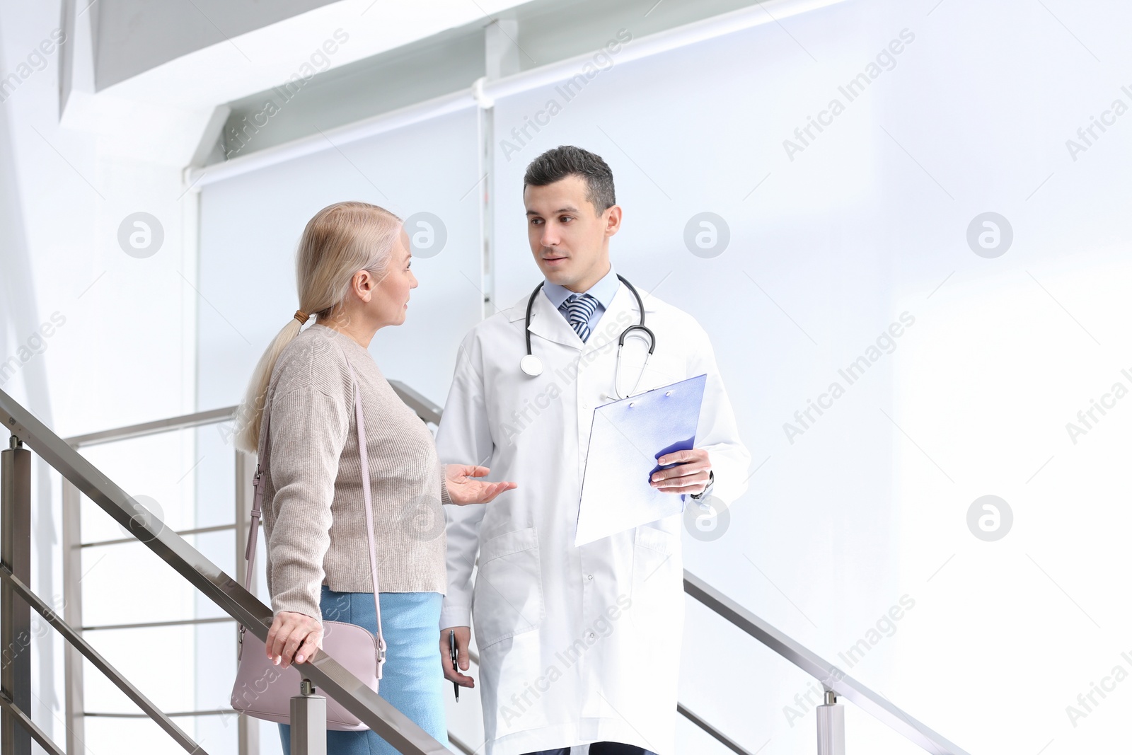 Photo of Doctor and patient discussing diagnosis on stairs in hospital