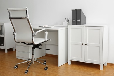 Photo of Stylish workplace interior with modern office chair and desk