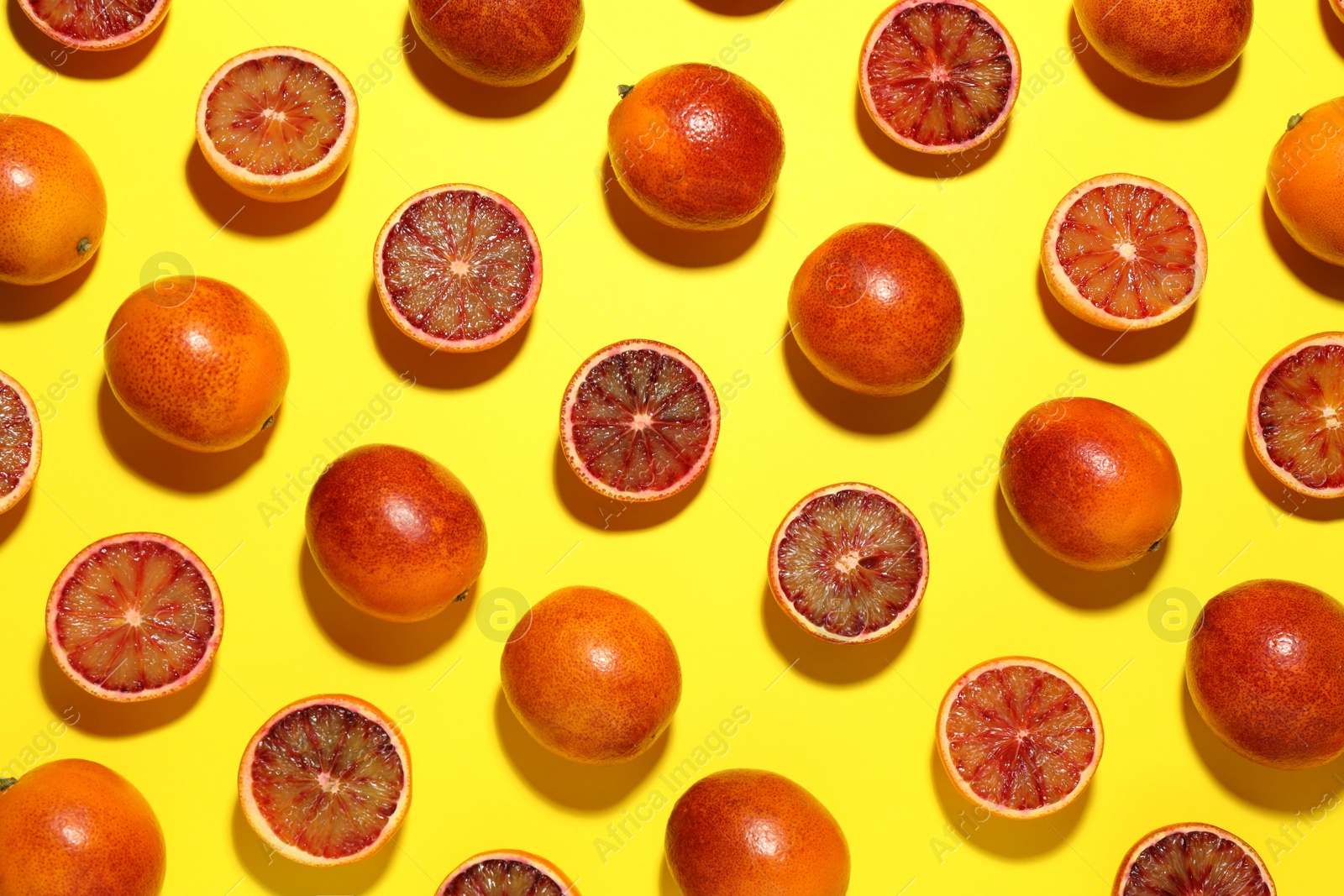 Photo of Many ripe sicilian oranges on yellow background, flat lay