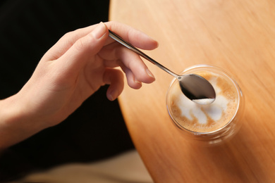 Woman with aromatic coffee at table in cafe, above view