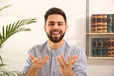 Photo of Young man using video chat at home, view from web camera