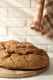 Photo of Freshly baked sourdough bread on white table