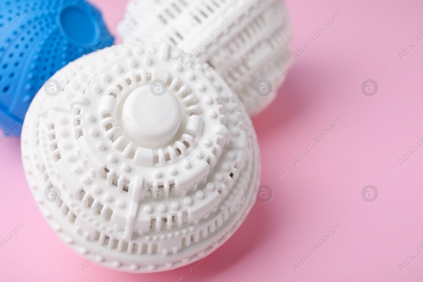 Photo of Laundry dryer balls on pink background, closeup. Space for text