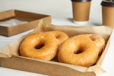 Photo of Delicious donuts in box on white table