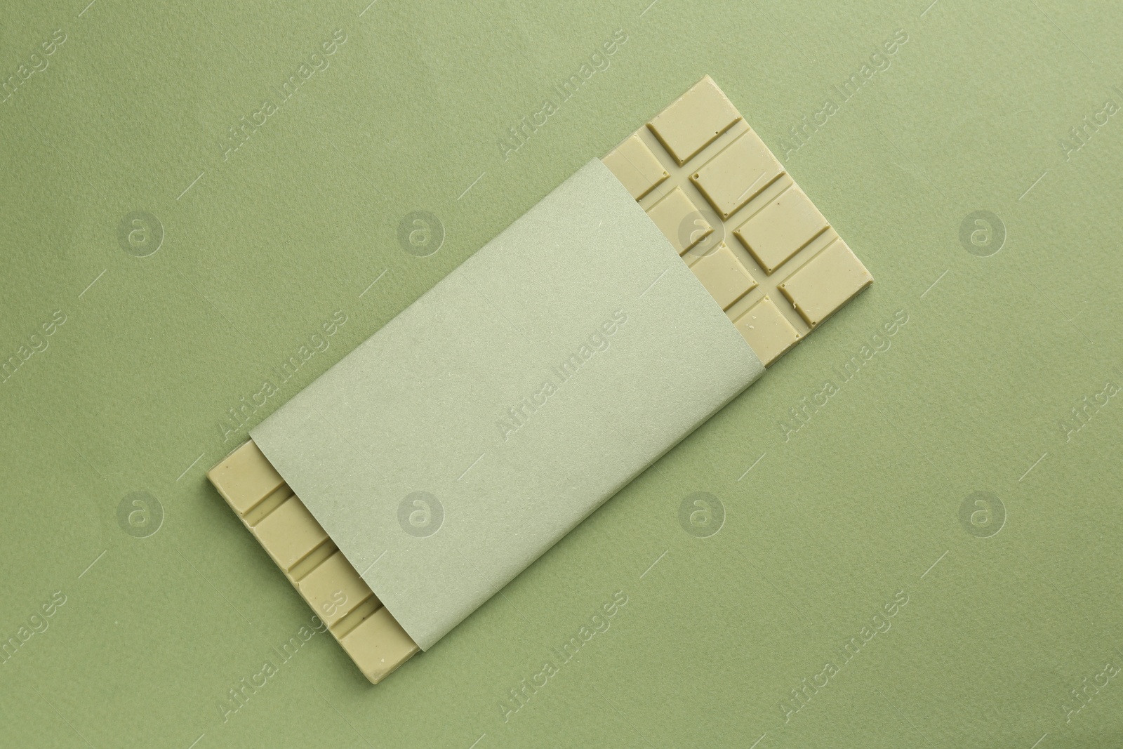Photo of Tasty matcha chocolate bar on green background, top view
