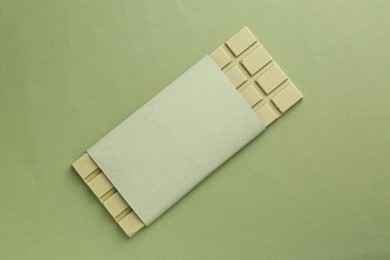 Tasty matcha chocolate bar on green background, top view
