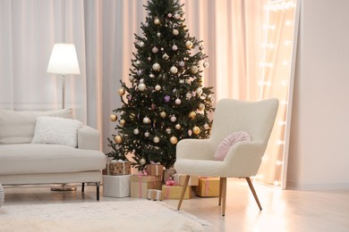 Photo of Beautiful Christmas tree near sofa in living room