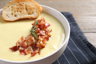 Tasty potato soup with bacon and crouton in bowl on table, closeup