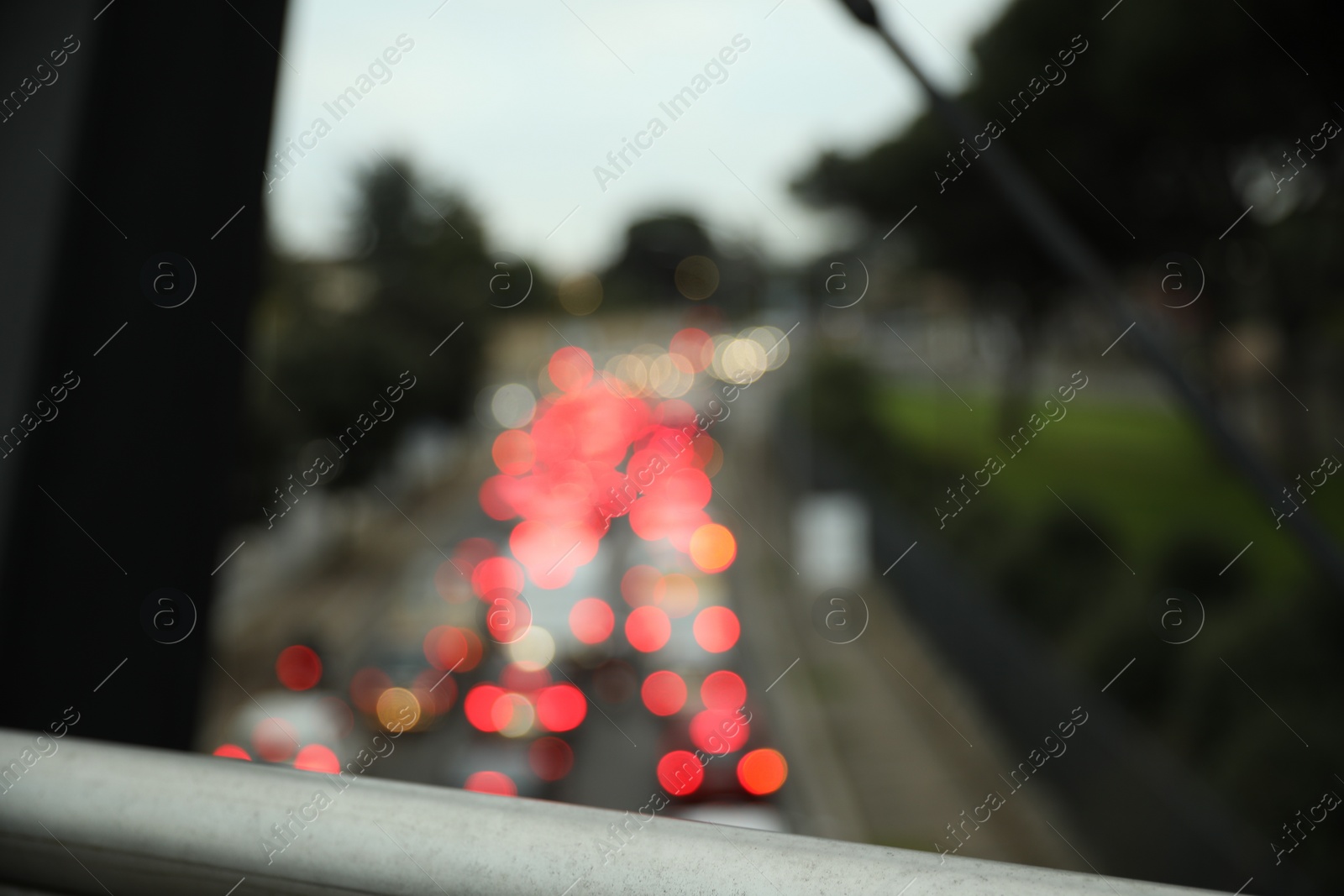 Photo of Blurred view of cars in traffic jam on city street in evening