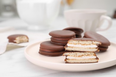 Photo of Plate with delicious choco pies on white marble table, closeup