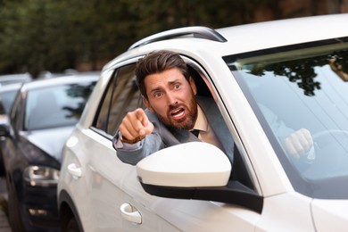 Photo of Angry driver screaming at someone from car in traffic jam