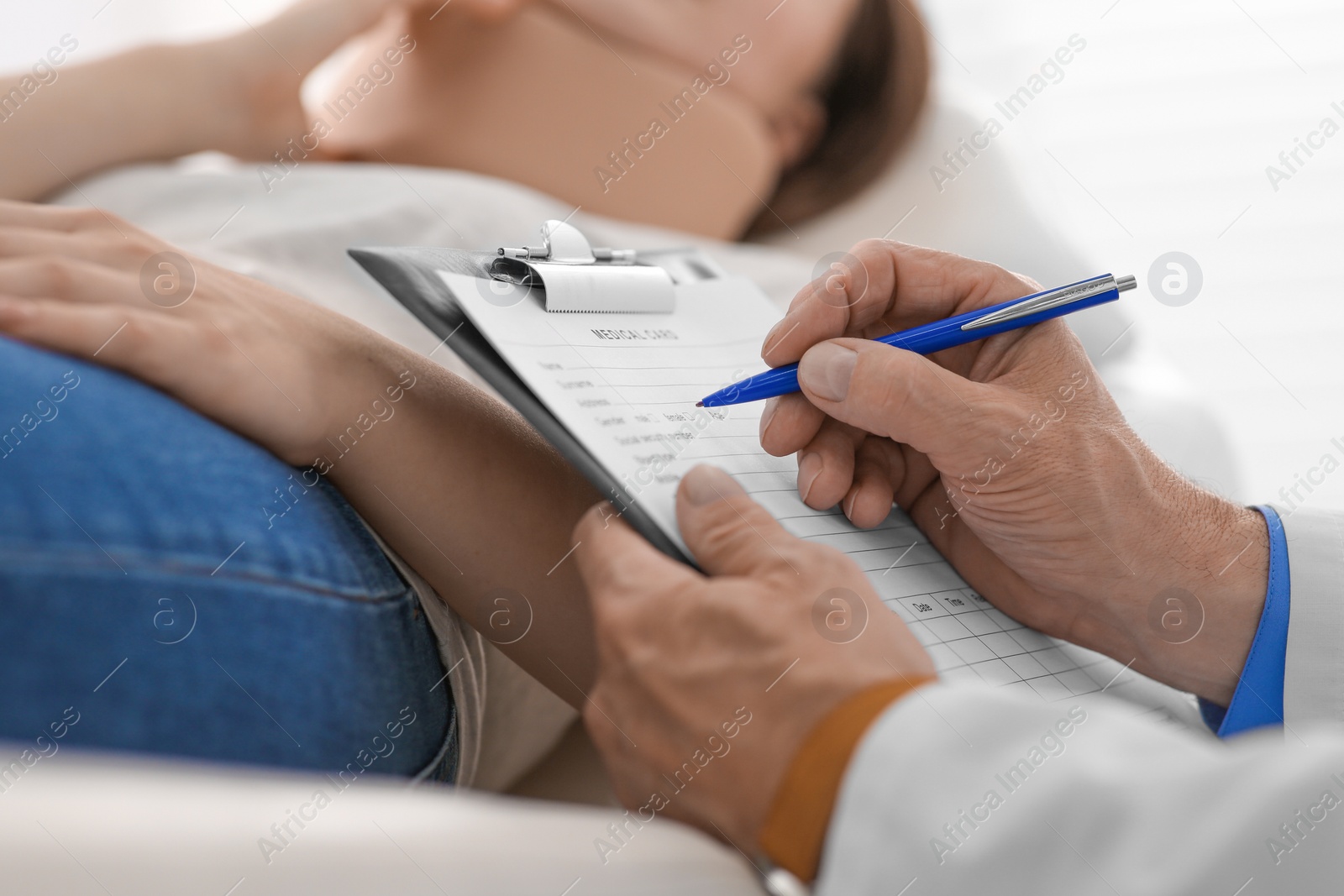 Photo of Doctor filling patient's medical card in clinic, closeup