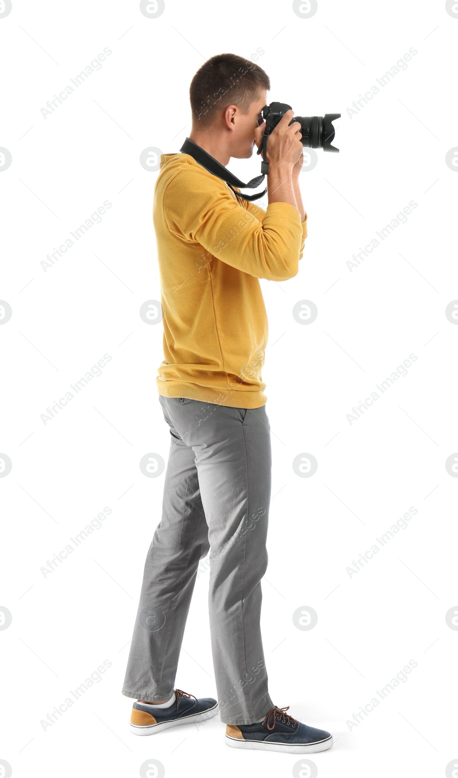 Photo of Young professional photographer taking picture on white background