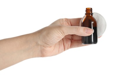 Photo of Woman holding bottle of medical iodine and cotton pad on white background, closeup