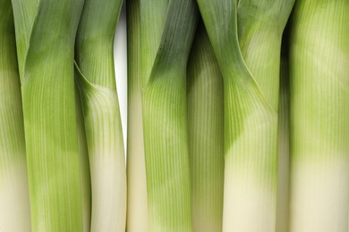 Fresh raw leeks as background, top view