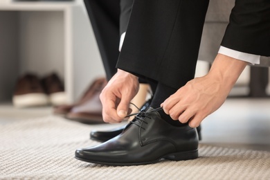 Young man trying on shoes in store