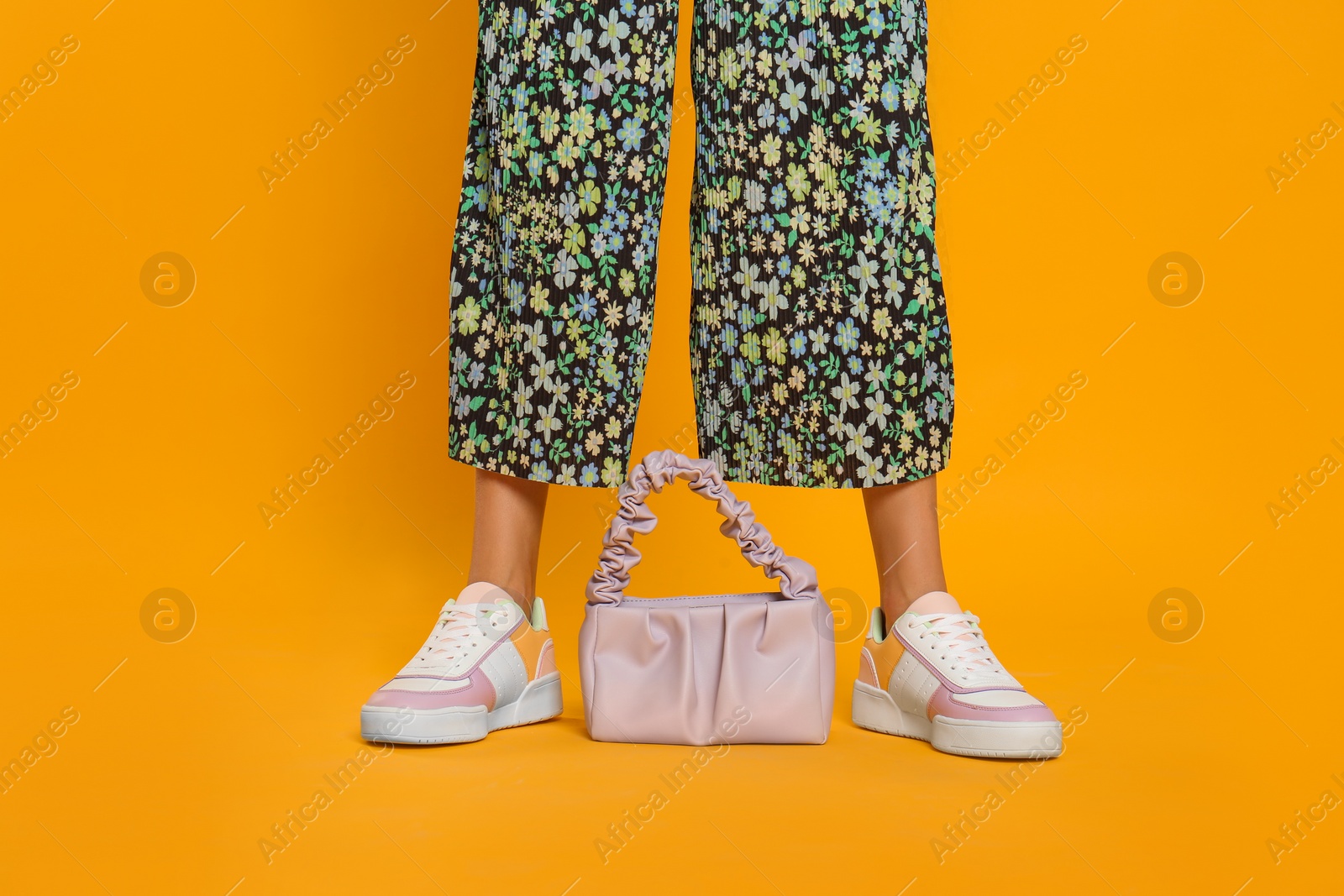 Photo of Woman with stylish bag on yellow background, closeup