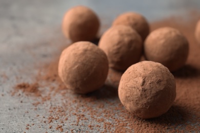 Photo of Delicious raw chocolate truffles on grey background, space for text