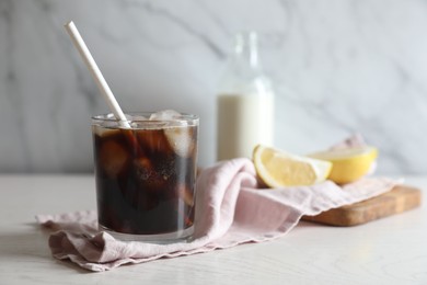 Photo of Refreshing iced coffee in glass on white wooden table