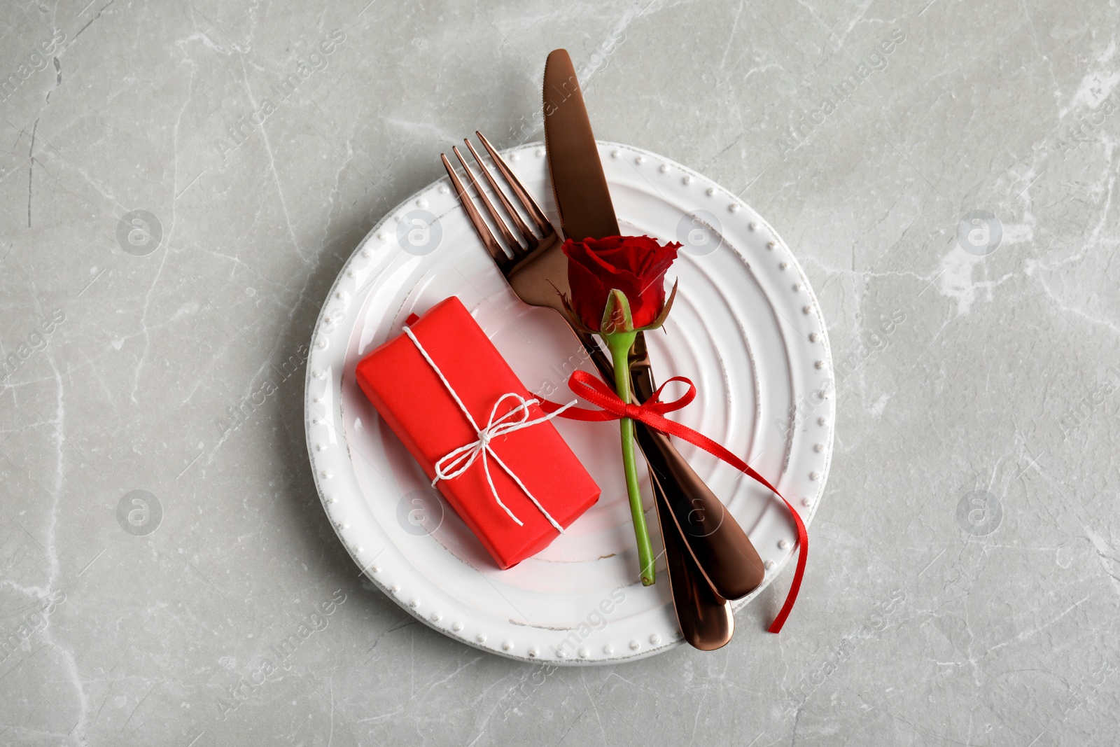 Photo of Beautiful place setting for romantic dinner on light grey table, top view. Valentine's day celebration