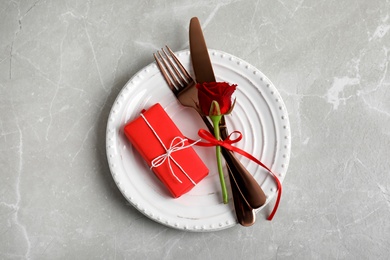 Beautiful place setting for romantic dinner on light grey table, top view. Valentine's day celebration