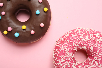 Delicious glazed donuts on pink background, flat lay