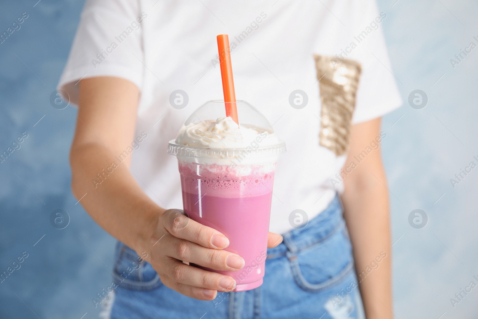 Photo of Woman with plastic cup of tasty milk shake on color background, closeup