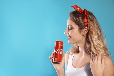 MYKOLAIV, UKRAINE - NOVEMBER 28, 2018: Young woman with Coca-Cola can on color background, space for text