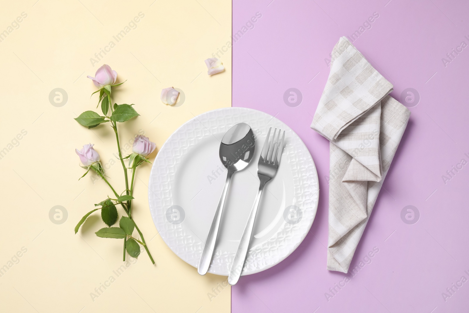 Photo of Beautiful table setting with roses on color background, flat lay