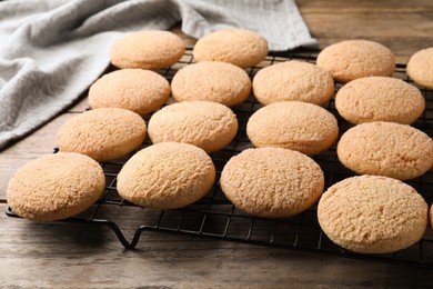 Photo of Many tasty sugar cookies on wooden table, closeup