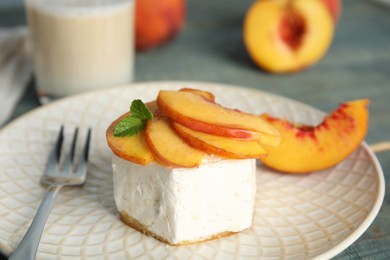 Photo of Delicious dessert with peach slices on plate, closeup