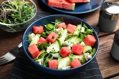 Photo of Delicious salad with watermelon served on wooden table