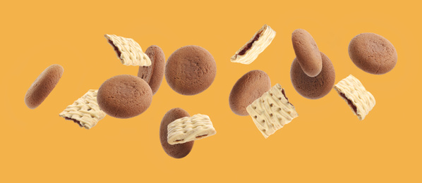 Image of Set of different falling cookies on yellow background. Banner design 