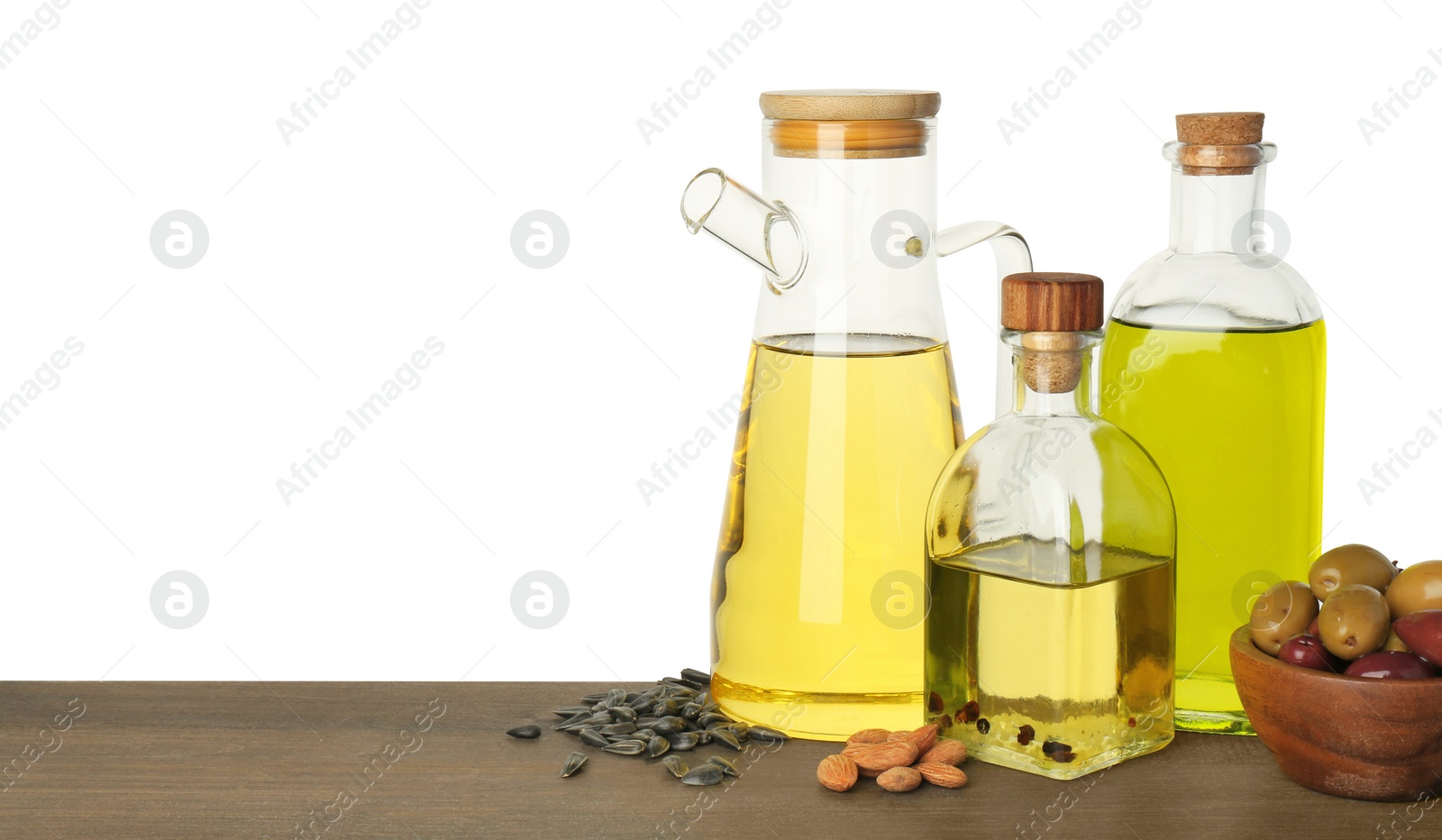 Photo of Vegetable fats. Different cooking oils and ingredients on wooden table against white background