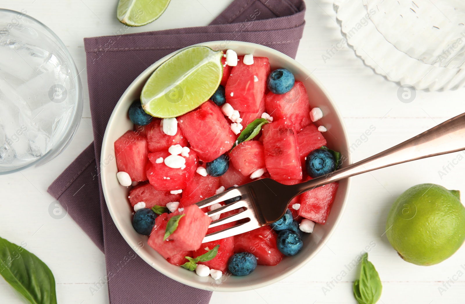 Photo of Delicious salad with watermelon, blueberries and cheese on white wooden table, flat lay