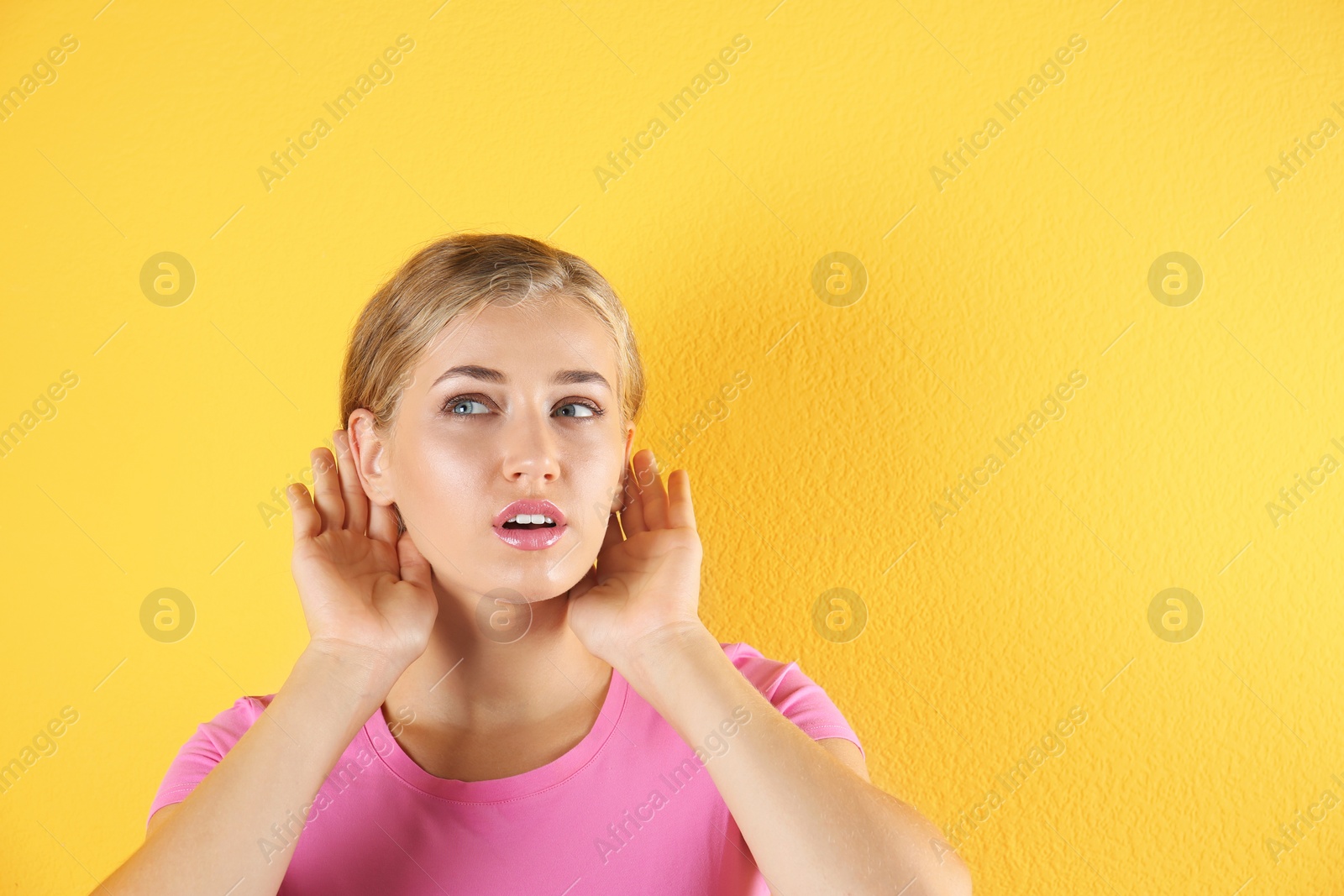 Photo of Young woman with hearing problem on color background. Copy space text