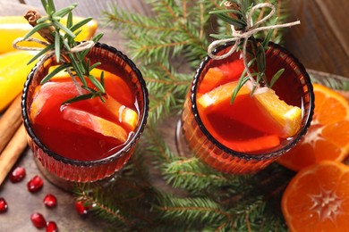 Photo of Christmas Sangria cocktail in glasses, ingredients and fir tree branches on wooden table, above view