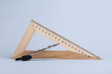 Photo of Triangle ruler and compass on white background