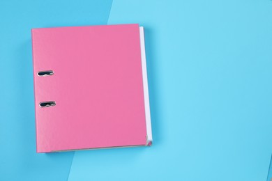 Photo of One office folder on light blue background, top view. Space for text