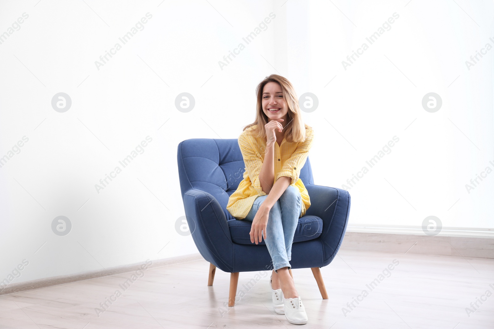 Photo of Young woman sitting in armchair at home