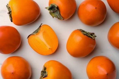 Photo of Delicious ripe persimmons on white table, flat lay