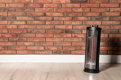 Photo of New modern electric heater on floor in room, space for text