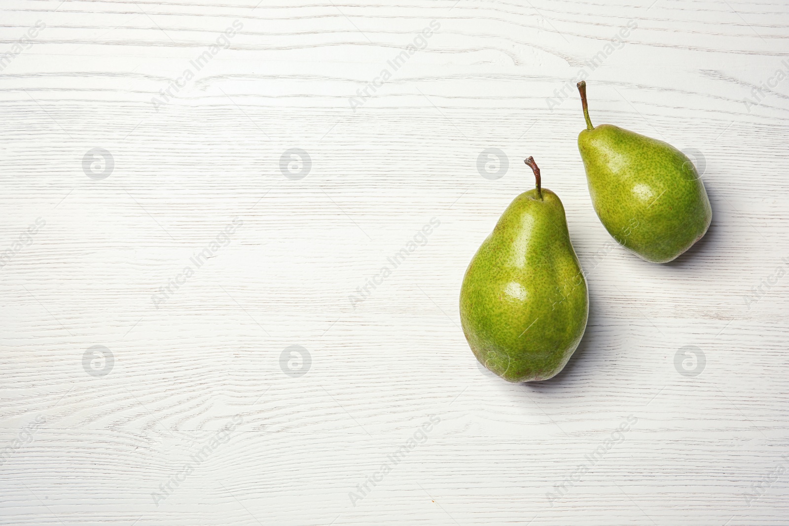 Photo of Ripe pears on wooden background, top view. Space for text