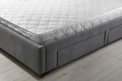 New light green mattress on gray bed indoors