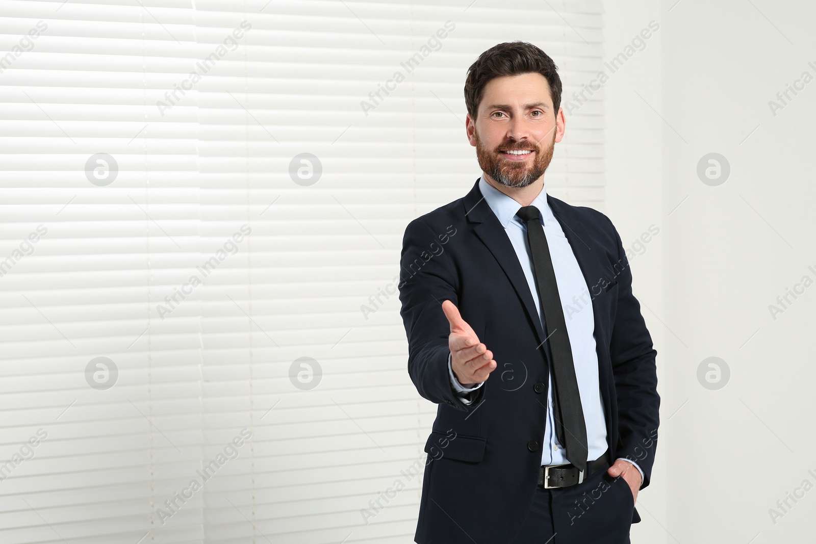 Photo of Handsome real estate agent in nice suit indoors, space for text