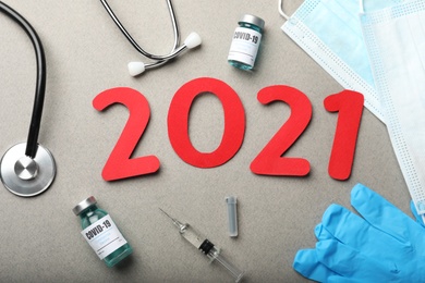 Photo of Flat lay composition with coronavirus vaccine and number 2021 on grey background