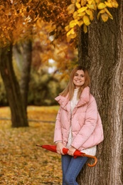 Woman with umbrella in autumn park on rainy day