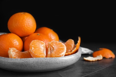Photo of Delicious fresh ripe tangerines on black table
