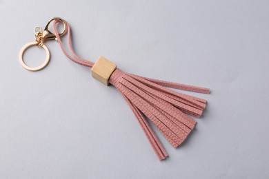 Pink leather keychain on light grey background, above view