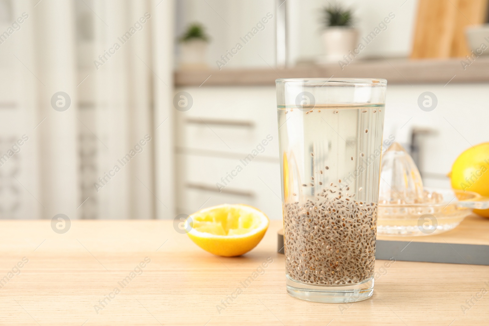 Photo of Composition with glass of water and chia seeds on table against blurred background, space for text